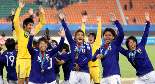 Japanese players celebrate after winning gold medal in Asian Games football final against the UAE. —AFP Photo